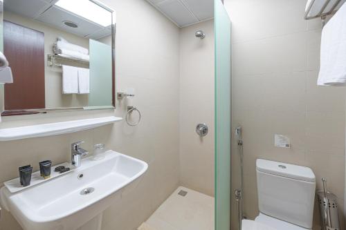 a bathroom with a sink and a toilet and a mirror at Maysan Rotana El Mysk Fully Renovated in Medina