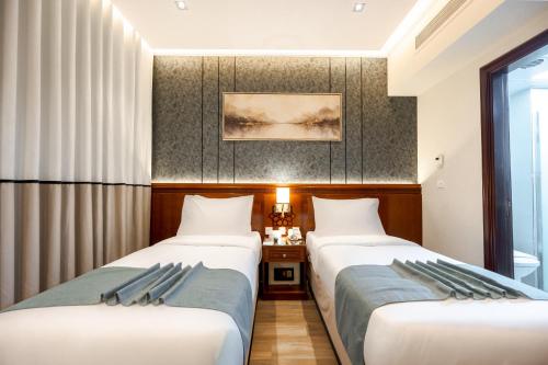 a hotel room with two beds and a window at Maysan Rotana El Mysk Fully Renovated in Medina