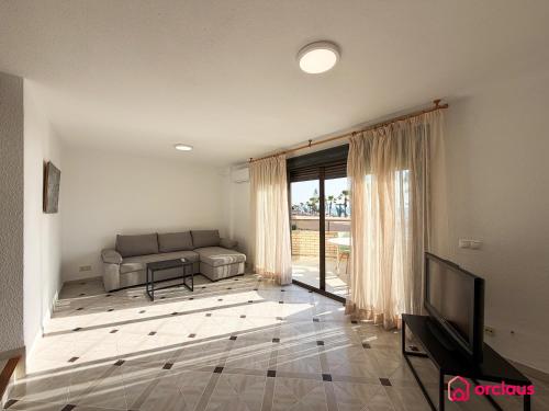a living room with a couch and a television at Poble Mar 2 in Oropesa del Mar