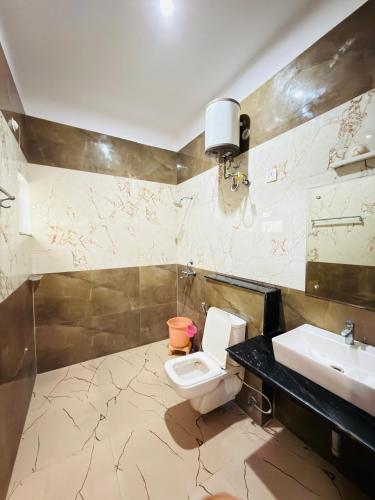 a bathroom with a toilet and a sink at Sirtaj Suites in Tājganj