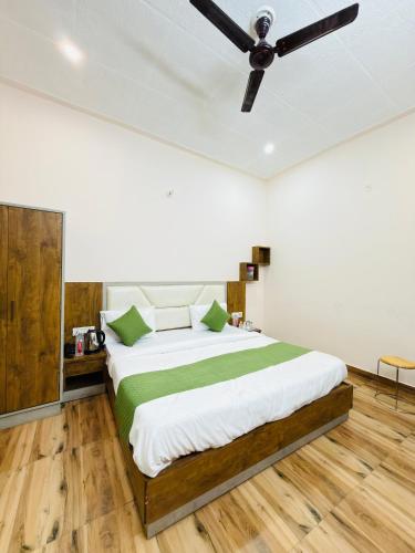 a bedroom with a bed with a ceiling fan at Sirtaj Suites in Tājganj