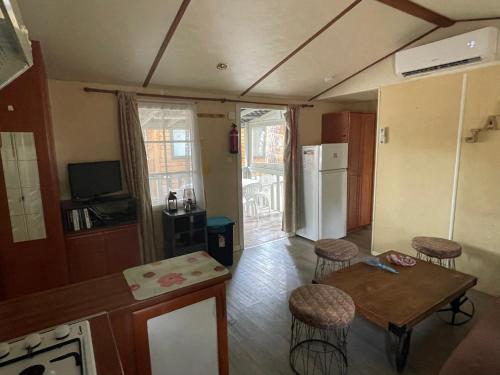 a living room with a table and chairs and a kitchen at Mobile Home Agde Les Sables D'or in Le Grau-dʼAgde