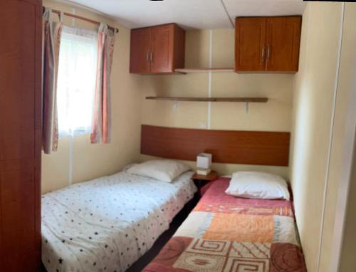 a small room with two beds and a window at Mobile Home Agde Les Sables D'or in Le Grau-dʼAgde