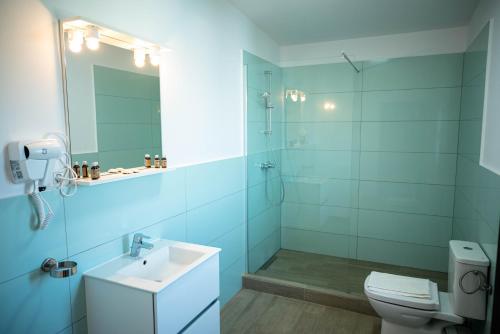 a bathroom with a toilet and a sink and a shower at Kazeboo Bed & Breakfast in Mamaia Sat/Năvodari