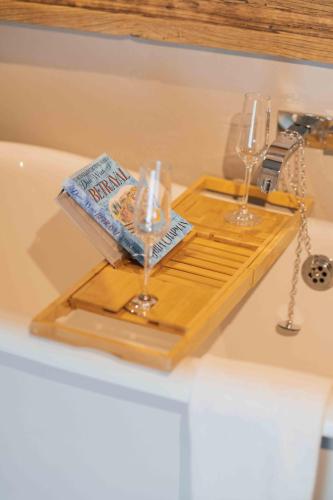 a tray with a book and glasses on a bath tub at Yorebridge House in Bainbridge