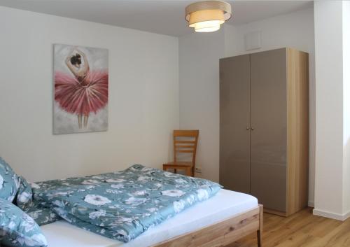a bedroom with a bed and a cabinet at Glöckle Mühle, Ferienwohnungen und Camping mit Sauna in Herbolzheim