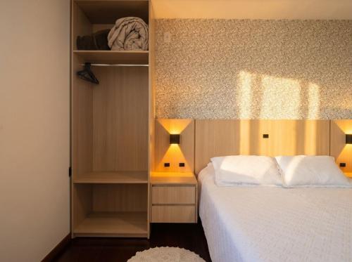 a bedroom with a bed and a book shelf at Hotel Somensi in Bento Gonçalves