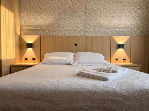 a bedroom with a bed with two towels on it at Hotel Somensi in Bento Gonçalves