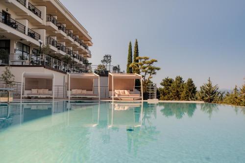 a large swimming pool with chairs and a building at Inex Olgica Hotel & SPA in Ohrid