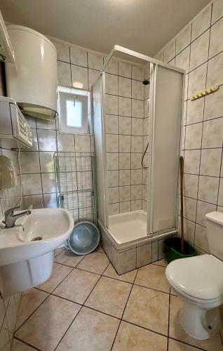 a bathroom with a sink and a shower and a toilet at Ośrodek Wczasowy BOBO in Koczała