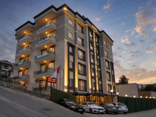 a large white building with cars parked in front of it at SWEET HOME SUiTE HOTEL in Trabzon