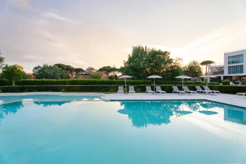 a large swimming pool with chairs and umbrellas at Smy Pisa Plaza in Pisa