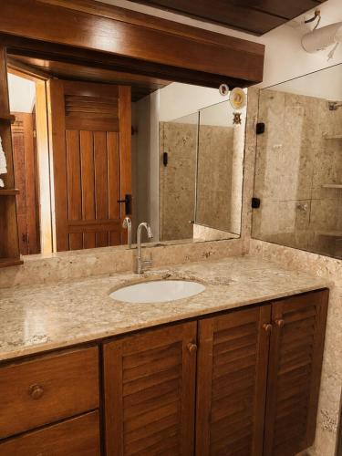 a bathroom counter with a sink and a mirror at Casaboa Casarão Boutique Orla in Itacaré