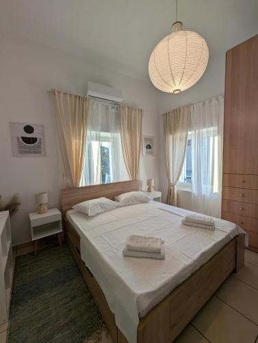 a bedroom with a large bed and a chandelier at Theros House in Ioulis