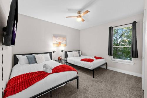 a bedroom with two beds and a tv and a window at Lux, Fenced Backyard 4 Pets, Firepit, Exec Desk in Dallas