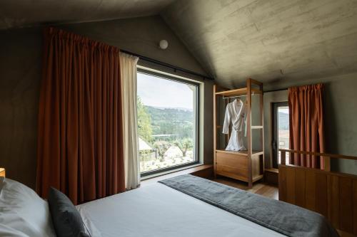 a bedroom with a bed and a large window at Passinhos House in Amarante