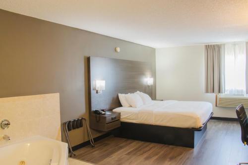 a hotel room with a bed and a bath tub at Quality Inn Spearfish I-90 in Spearfish