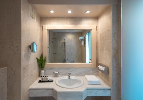 a bathroom with a sink and a mirror at Canvas by Mitsis Cretan Village in Hersonissos