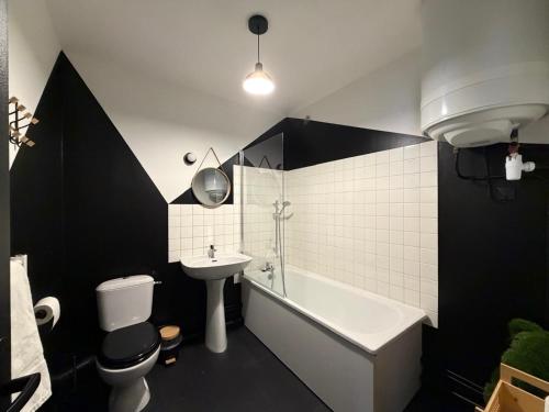 a bathroom with a tub and a toilet and a sink at L'échiquier royal-Studio chic proche château fort in Sedan