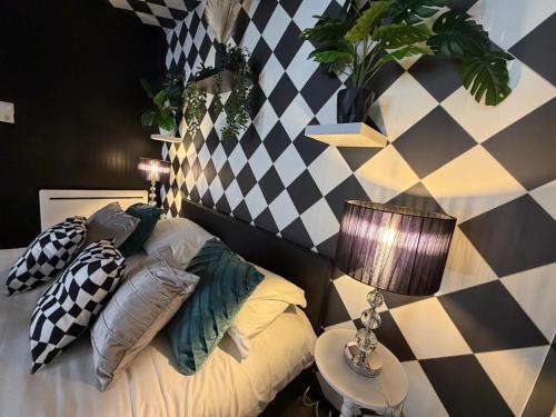 a bedroom with a bed with pillows and a lamp at L'échiquier royal-Studio chic proche château fort in Sedan