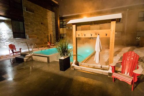 a swimming pool with two chairs and a umbrella at Hotel V in Gatineau