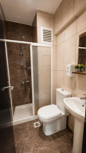 a bathroom with a shower and a toilet and a sink at Grand Erdek Hotel in Erdek