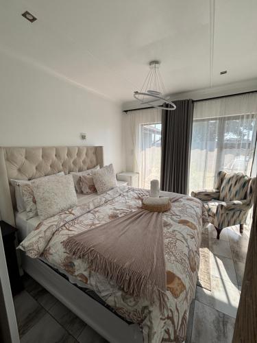 a bedroom with a large bed with a large window at Randhart guesthouse in Alberton