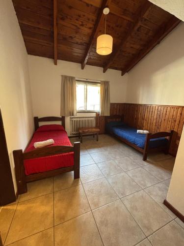 a living room with two beds and a window at Hostel Inn Bariloche in San Carlos de Bariloche