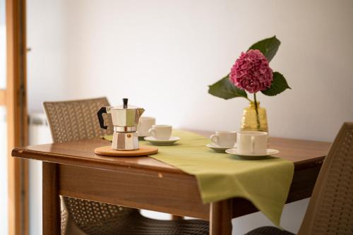 a table with a coffee maker and a vase with a flower at Residence Da Carmelo in Palinuro