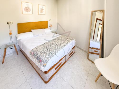 a bedroom with a large bed and a mirror at Xilgar Apto Proa 2d encima de la playa in Raxó