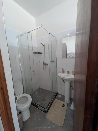 a bathroom with a shower and a toilet and a sink at Mirage in Tarrafal