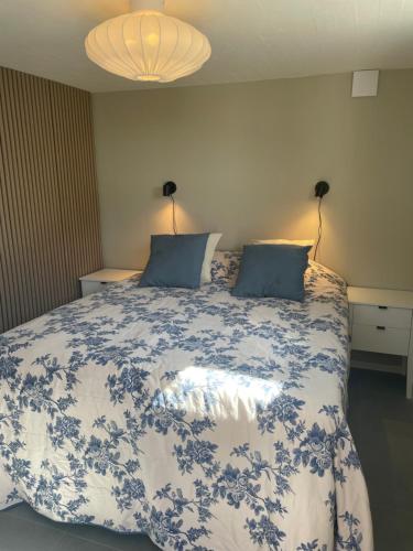 a bedroom with a bed with a blue and white comforter at Tallgatan Garden in Fjällbacka