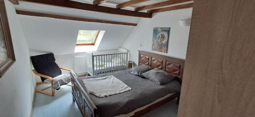 a small bedroom with a bed and a chair at Hébergement VIGNES ET RIVIERES in Écuelles