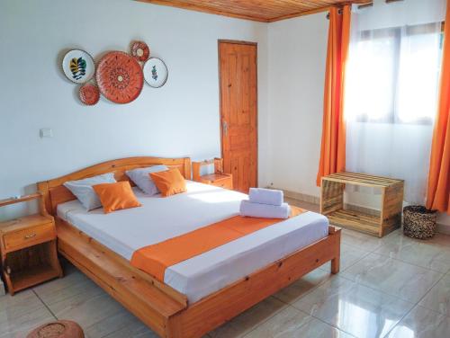 a bedroom with a large wooden bed in a room at Les Jardins d'Areca in Antsirabe