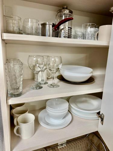 a cupboard filled with plates and glasses and dishes at Luxury Apartments Ekaterina in Chernomorets