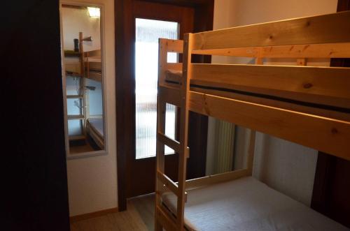 a bunk bed in a room with a window at Immeuble Belvédère in Les Collons