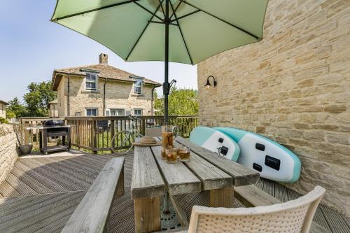 a wooden table with an umbrella on a deck at Moorhens in Somerford Keynes