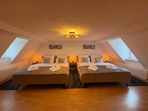 two beds in a attic room with two lamps at MARKINA - Ferienwohnung - Kiliani I in Mühlhausen