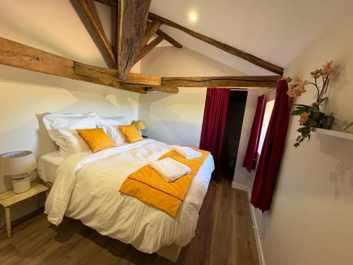 a bedroom with a bed with white sheets and orange pillows at Domaine de la Briouse in Sanxay