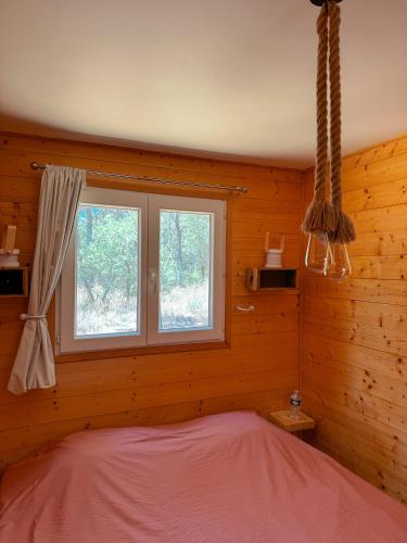 a bedroom with a bed and a window at La Petite Maison d'Emma in Vidauban