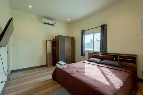 a bedroom with a large bed and a window at Blue Lake Residences - Pattaya in Nong Prue
