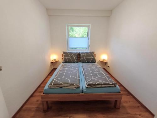 a small room with a bed with two lights on it at Janas Pfälzerwaldglück in Lemberg