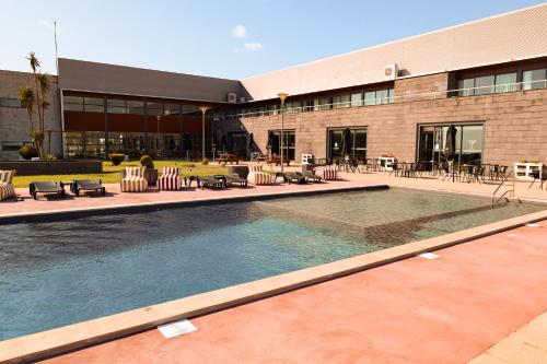 a swimming pool in front of a building at Hotel Colombo in Vila do Porto