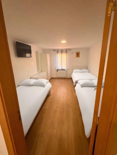 two beds in a room with wooden floors at Ca la Selma in Aiguamurcia