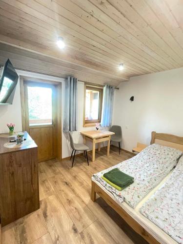 a bedroom with a bed and a desk and a table at Akacjowe Wzgórze in Ruciane-Nida