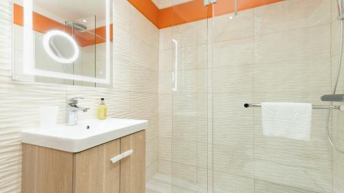 a bathroom with a sink and a glass shower at Cliff Refuge by LovelyStay in Santa Cruz