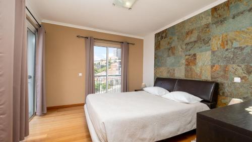 a bedroom with a bed and a large window at Cliff Refuge by LovelyStay in Santa Cruz