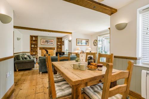 a kitchen and living room with a wooden table and chairs at Moorhens in Somerford Keynes