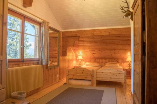 a bedroom with a bed in a wooden room at Chalet Les Rhodos in Vex