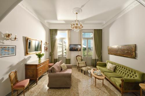 a living room with a green couch and chairs at Athenian Vintage Apartments in Athens